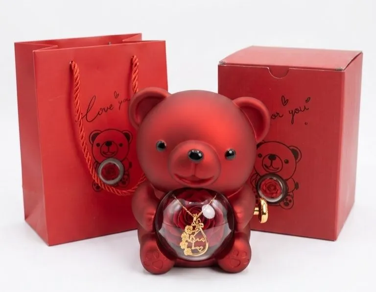 A red teddy bear with a rose inside